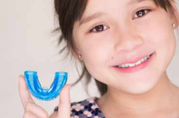 A small girl holding a myobrace
